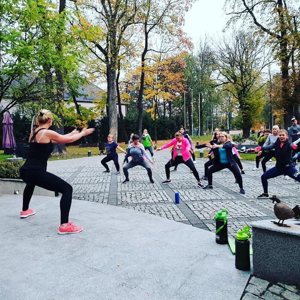 Distributor leading a fitness workout of people outdoors