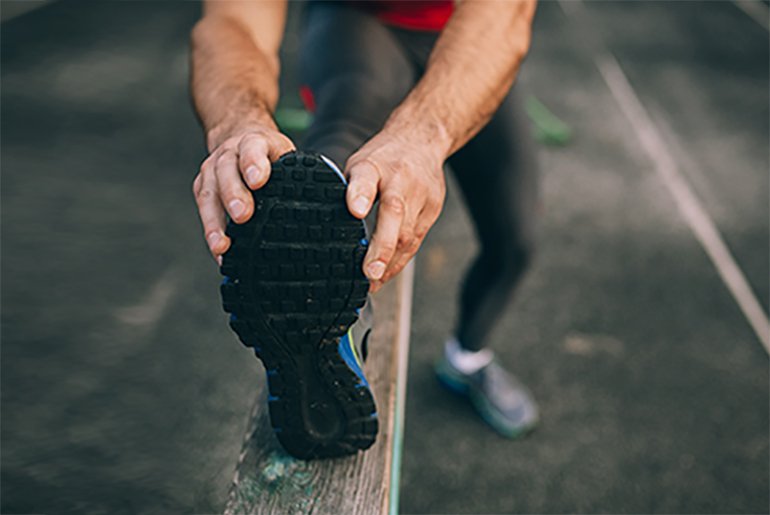 Man touching his foot while stretching